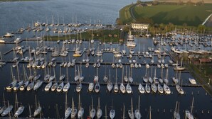 A marina with numerous boats docked in a structured layout. - Enjoy in the harbor at Veerse Meer. (Wolphaartsdijk)