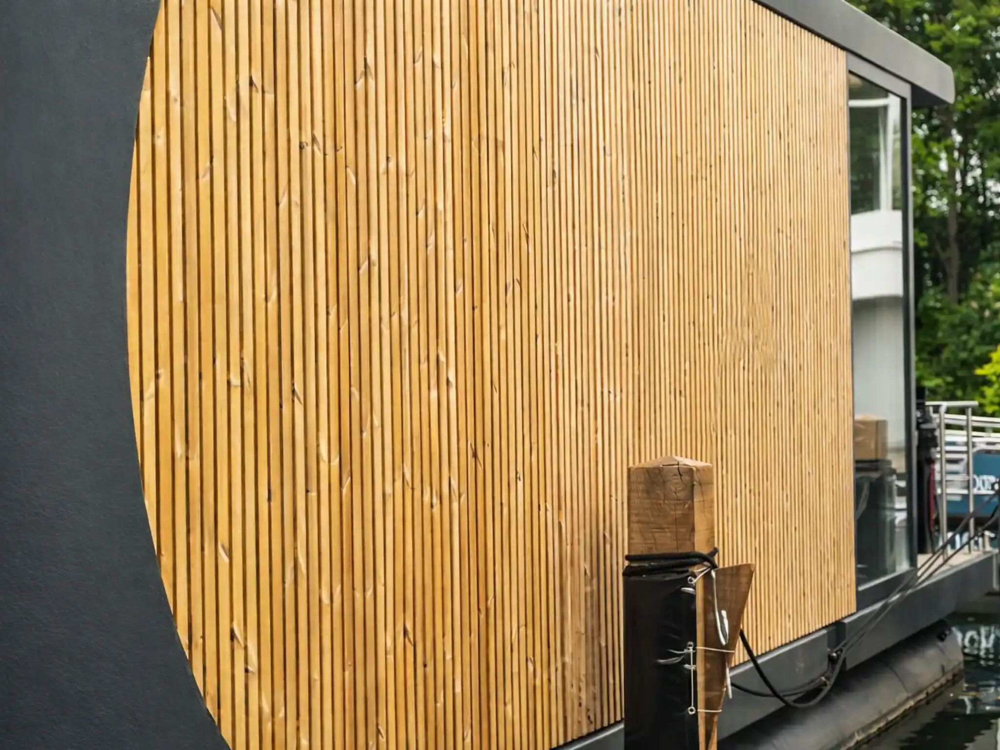 Ein modernes Gebäude mit Holzfassade und einem großen Fenster.