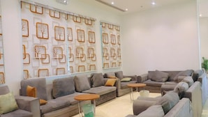 A modern living room with sofas, a coffee table, and decorative wall art.