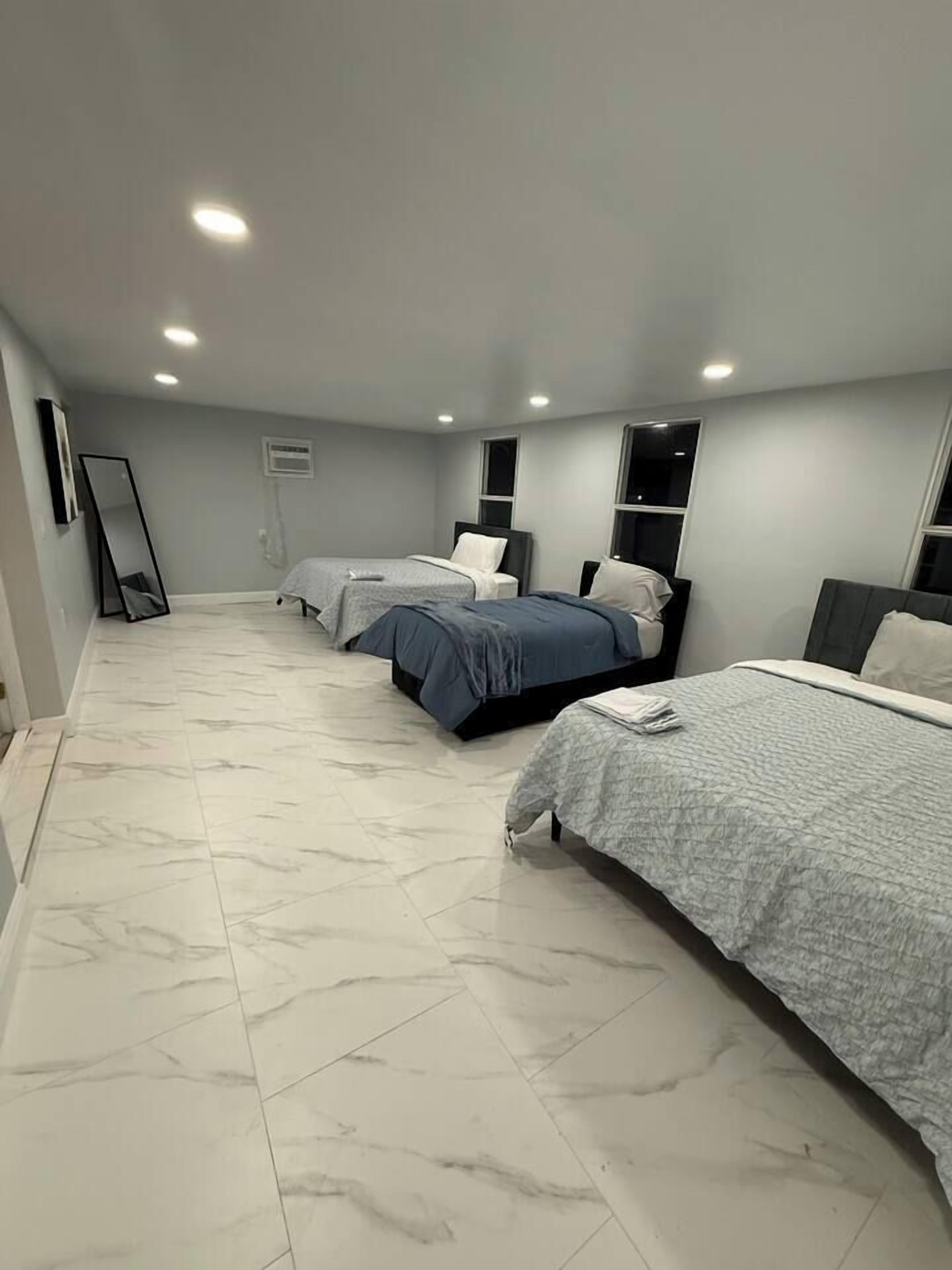 A bedroom with two beds, a mirror, and a wardrobe.