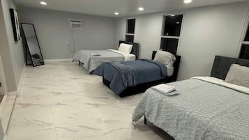 A bedroom with two beds, a mirror, and a wardrobe.