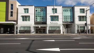 A modern building with a storefront labeled 'SOJOURN' and a clear road in front.