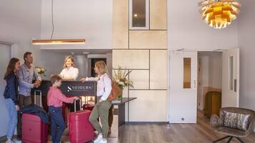 A reception area with a desk, a sign that reads 'SOJOURN,' and a modern interior design.