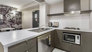 Una cocina moderna con lavavajillas, estufa y microondas empotrado.