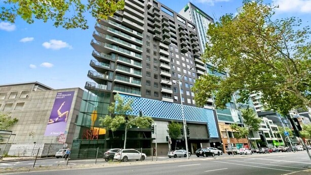Un edificio de varios pisos con un diseño arquitectónico moderno, que cuenta con balcones y ventanas amplias.