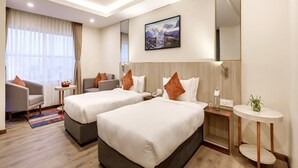 A hotel room with two beds, a sofa, a small table, a mirror, and a painting on the wall. - Regenta Place Sabrina Kathmandu (Burhanilkantha)