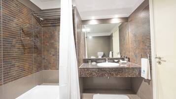 A modern bathroom with a shower, a sink, and a mirror.