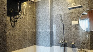 Baño con inodoro, ducha, lavamanos y calentador de agua.