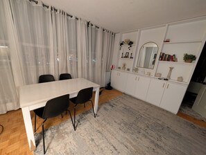 Eine moderne Küche mit weißen Schränken, einer weißen Arbeitsplatte und einem großen Spiegel über dem Spülbecken.