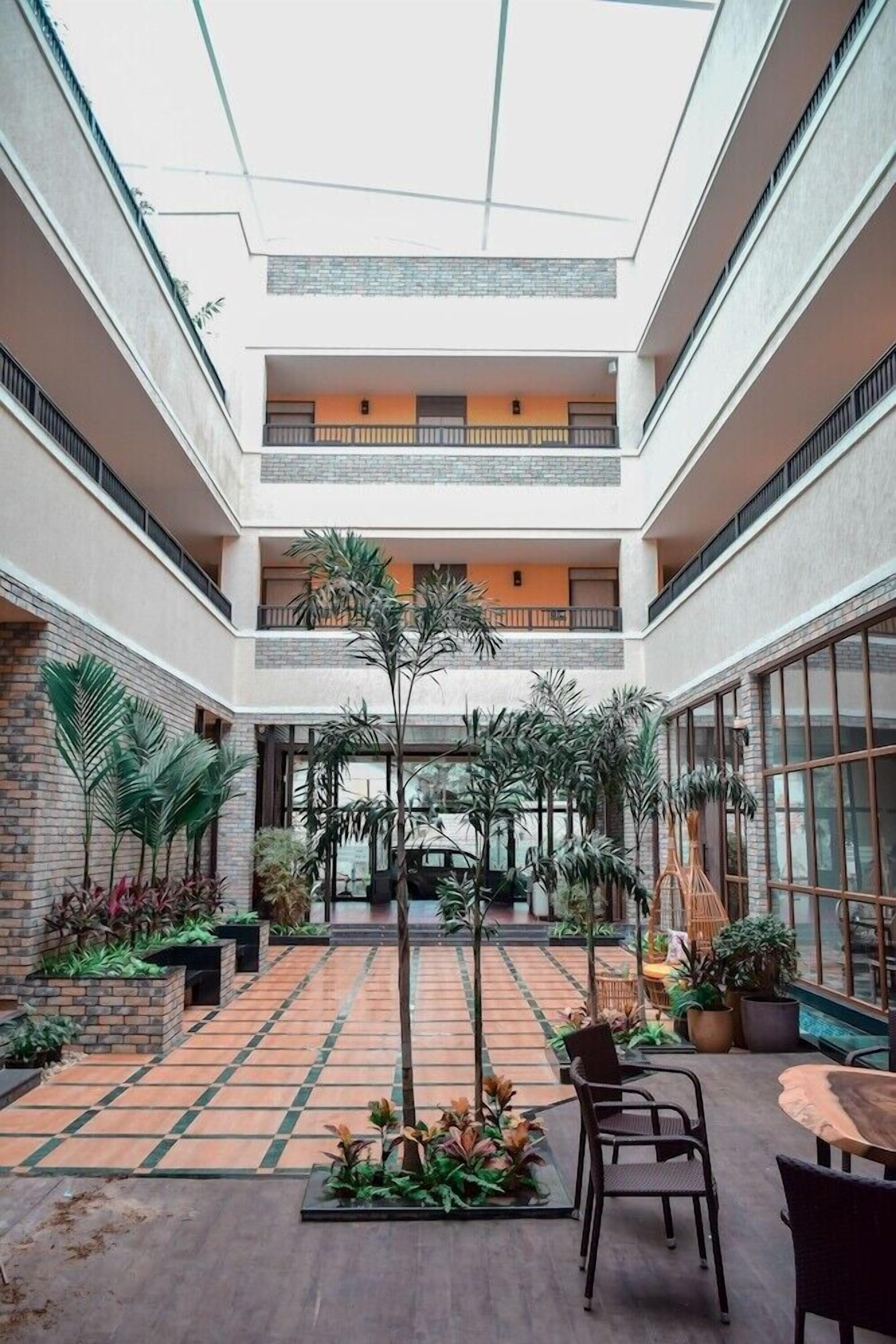 A multi-level atrium with a central open space, surrounded by balconies and potted plants.