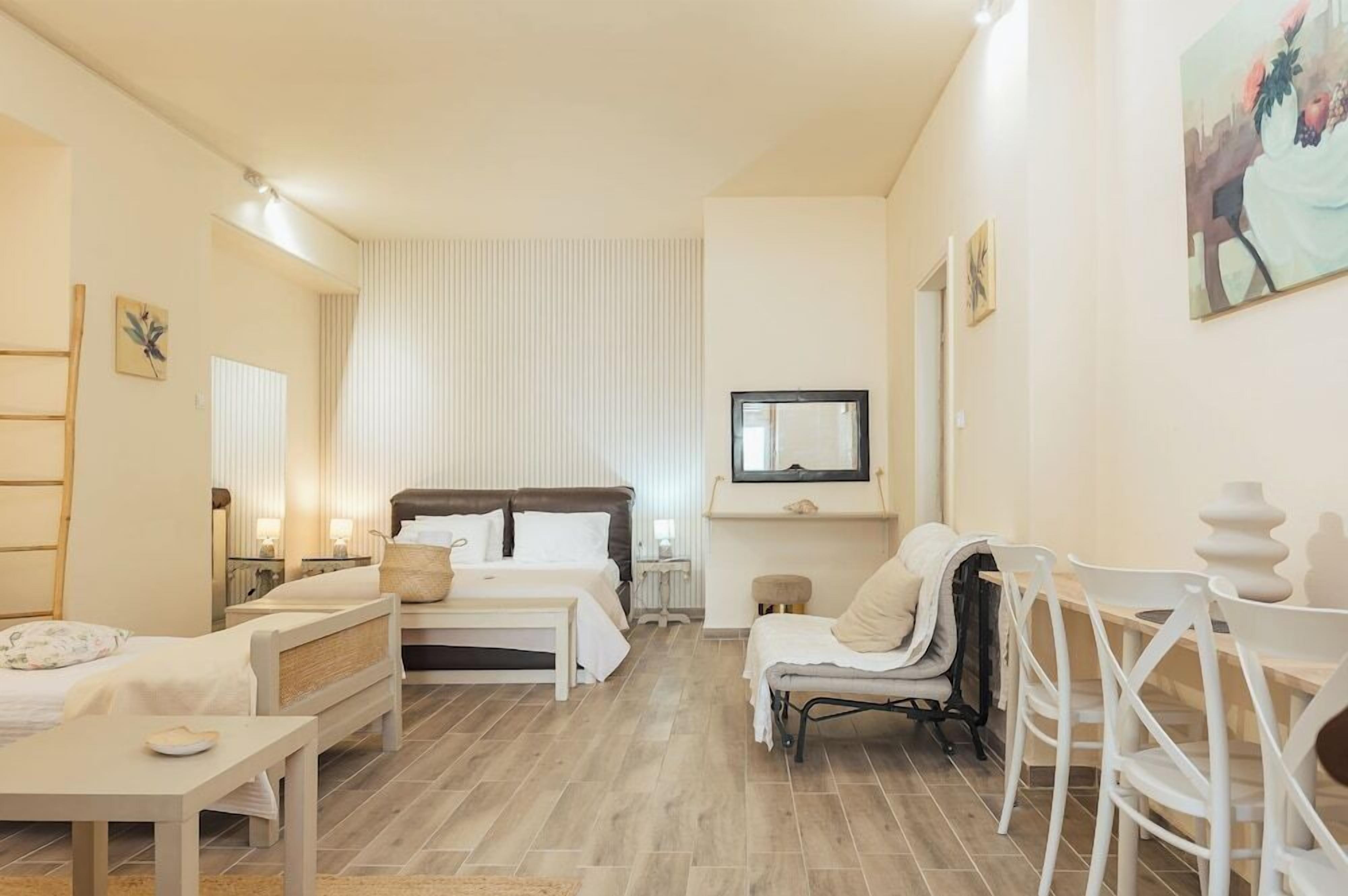 Una camera da letto con un letto, comodini, una sedia e una televisione.