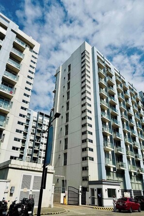 A multi-story residential building with balconies, a gated entrance, and a clear sky. - Dels Condotel by Zuzu (Pasay)