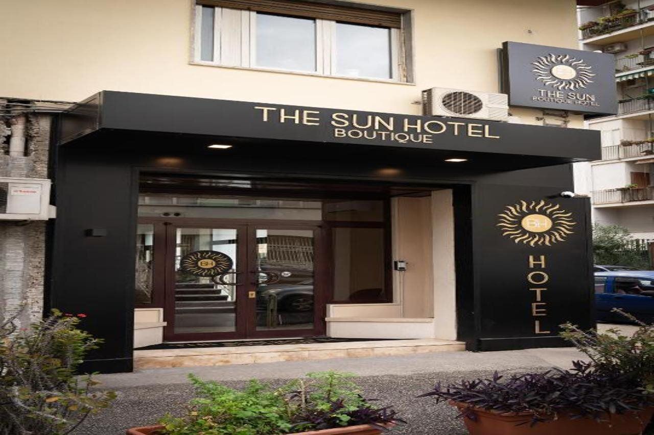 A hotel entrance with a sign reading 'The Sun Hotel Boutique.'