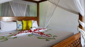 A bed with a canopy, pillows, and a decorative item on the headboard. - F-zeen Boutique Hotel Zanzibar (Uroa)