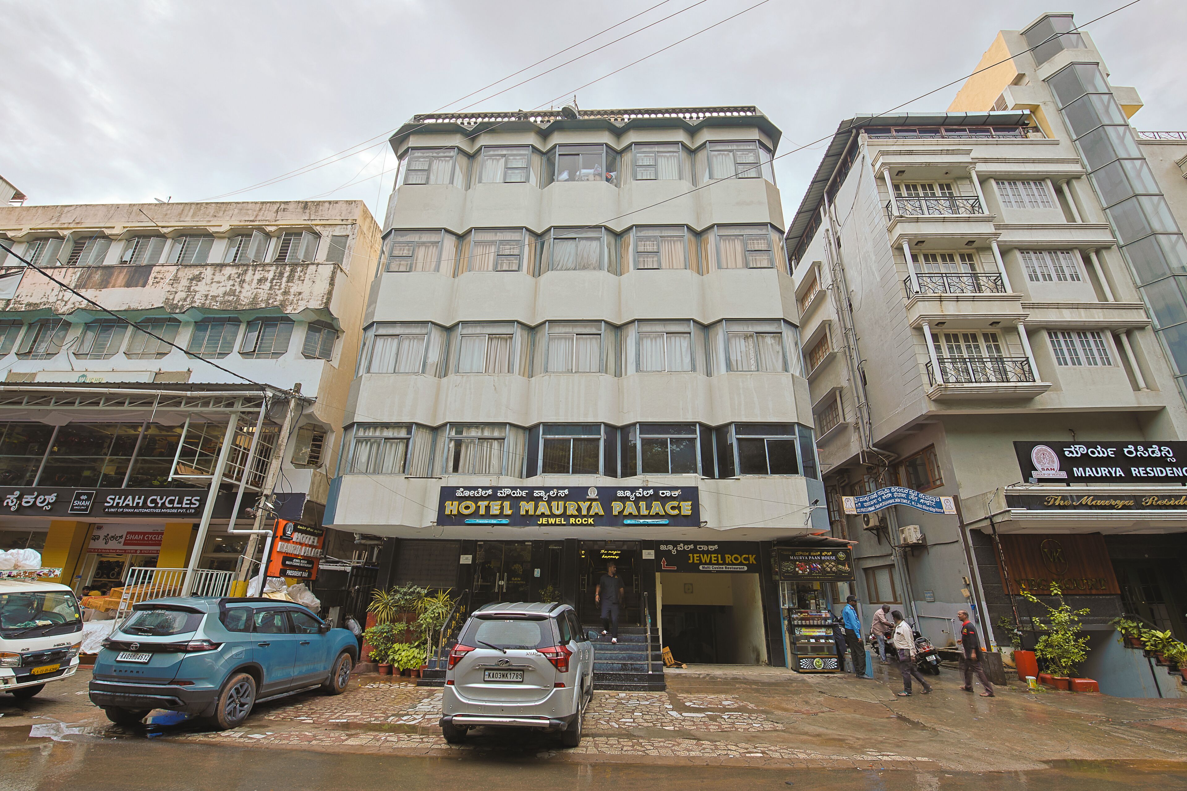 A multi-story hotel with a prominent sign for 'Hotel Maurya Palace.'