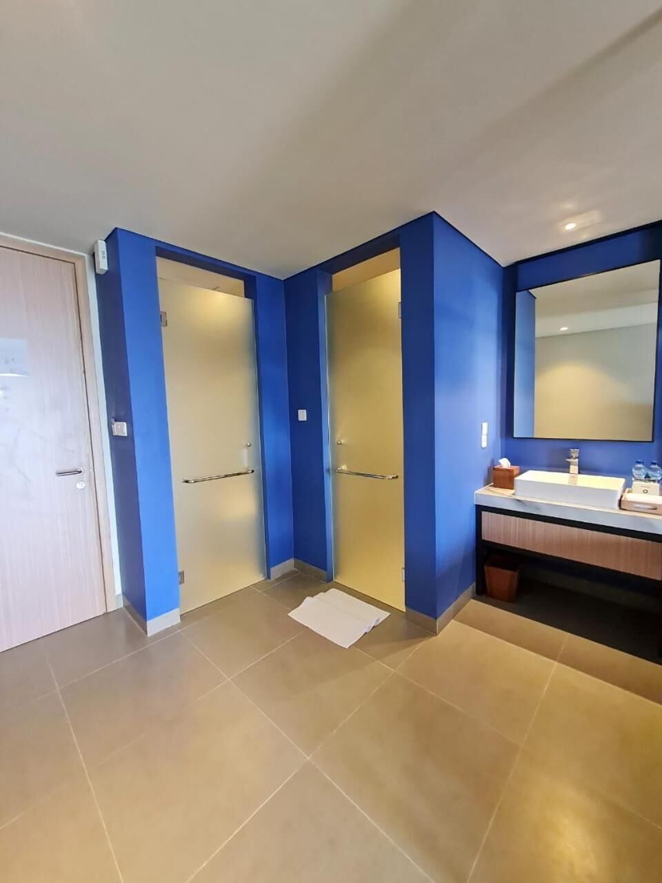 A bathroom with a blue wall, a white sink, and a mirror.