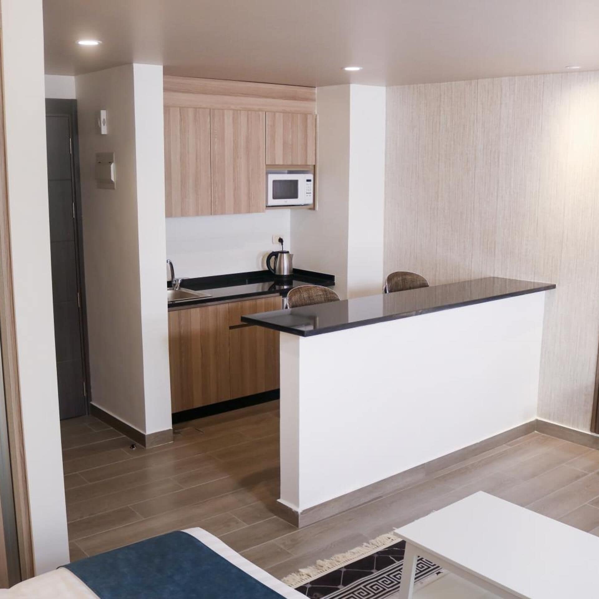 Una cocina moderna con una isla central, armarios de madera y un microondas.