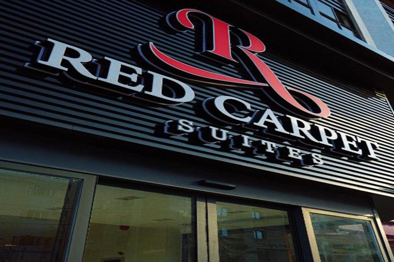 Un letrero de hotel con el nombre 'RED CARPET SUITES' en letras negritas.