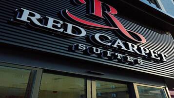 Un letrero de hotel con el nombre 'RED CARPET SUITES' en letras negritas.