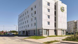 A modern hotel building with a flat facade, multiple windows, and a prominent B&B Hotels sign. - B&B Hotel Meaux Nanteuil-les-meaux (Nanteuil-les-Meaux)