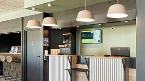 A hotel reception desk with a computer, a phone, and a menu board. - B&B Hotel Meaux Nanteuil-les-meaux (Nanteuil-les-Meaux)
