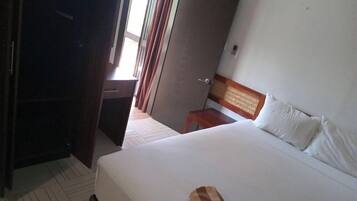 A hotel room with a bed, a desk, and a wardrobe.