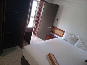 A hotel room with a bed, a desk, and a wardrobe. - Dreamview Villas (Rakiraki)