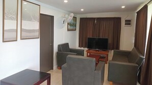 A living room with a sofa set, a television, and a fan. - Dreamview Villas (Rakiraki)