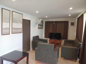 A living room with a sofa set, a television, and a fan. - Dreamview Villas (Rakiraki)
