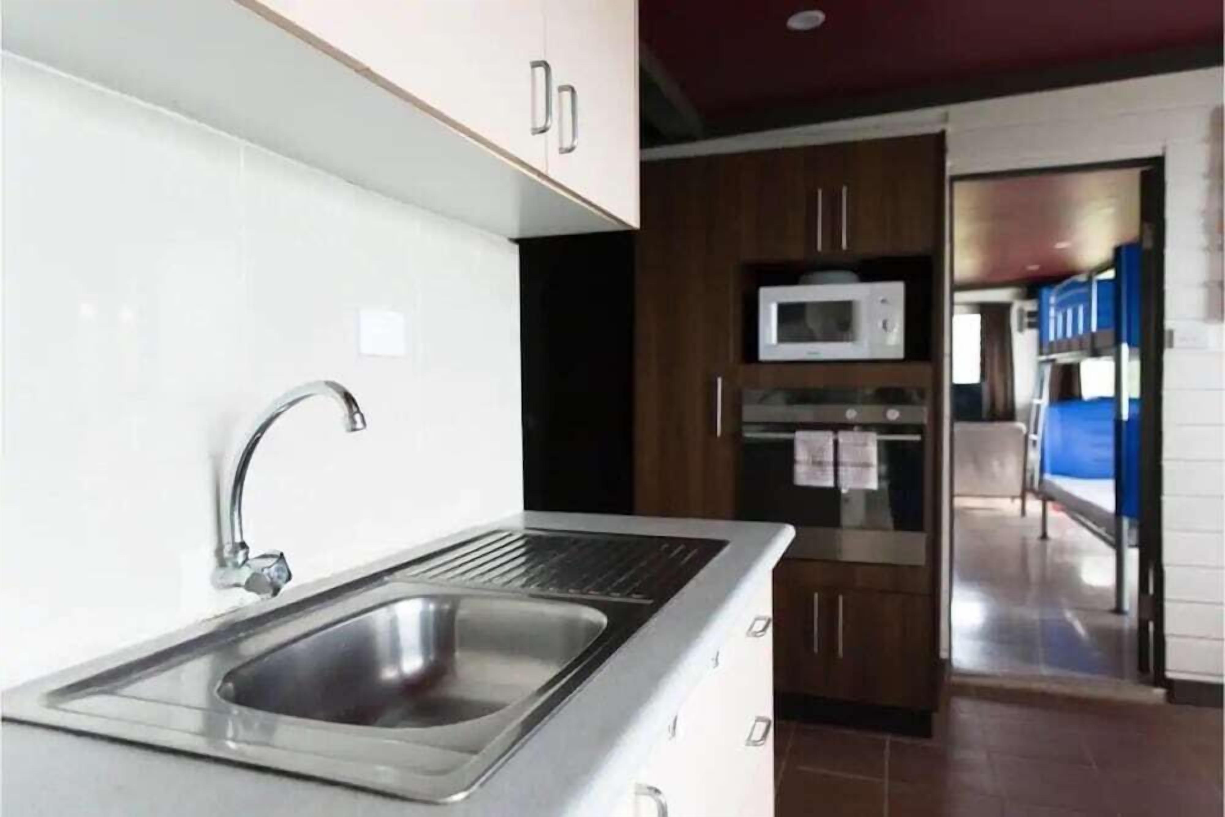 Uma cozinha moderna com eletrodomésticos de aço inoxidável, micro-ondas embutido e pia.