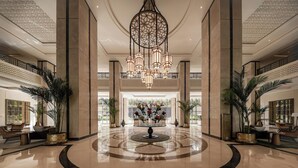 A spacious lobby with a central fountain, high ceilings, and a grand chandelier. - Giza Palace (Sheikh Zayed City)