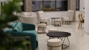 A modern living room with a sofa, armchairs, a coffee table, and a TV. - Liberty (Nafplio)