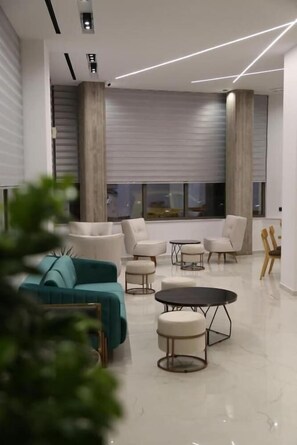 A modern living room with a sofa, armchairs, a coffee table, and a TV. - Liberty (Nafplio)