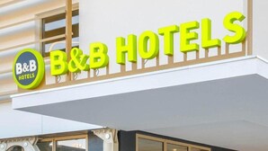 Un letrero de un hotel tipo B&B, con un logotipo circular y el nombre en letras negritas.