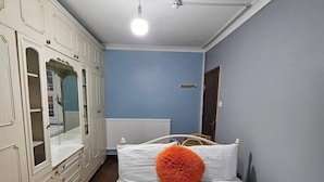 A bedroom with a bed, white wardrobe, and a blue wall. - Snoozeden Wellesley - Near to Slough Station (Cardiff)