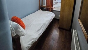 A small, single-bed room with a wooden ladder, a wardrobe, and a window with a view of the street. - Snoozeden Wellesley - Near to Slough Station (Cardiff)
