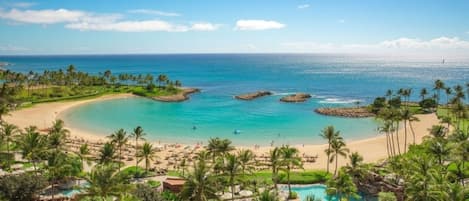 Un complexe hôtelier doté d’une piscine, d’une plage et offrant une vue sur l’océan.