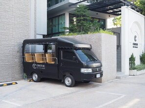 A black van parked in front of a building with a sign that reads 'CHATEAU DU VILLAGE.' - Chateau Du Village Patong (Krabi)