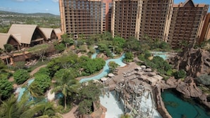 Un resort con diverse piscine, una cascata e vegetazione lussureggiante.