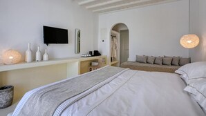 Una camera da letto con un letto, una scrivania e una televisione.