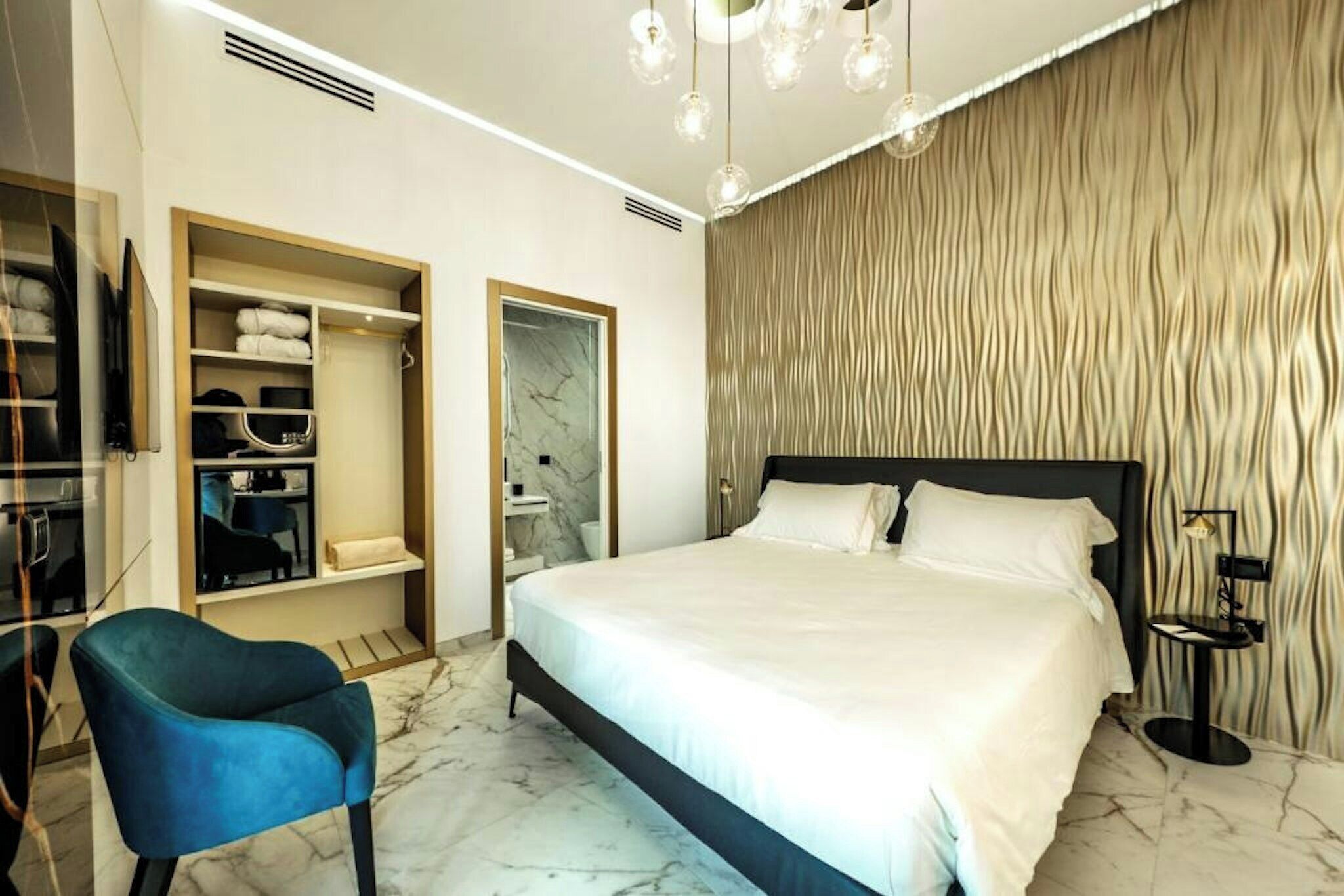 Ein modernes Schlafzimmer mit Bett, Kleiderschrank und einer Sitzecke.
