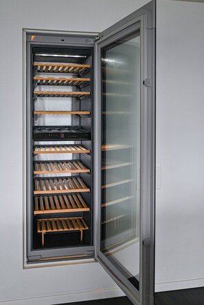 A modern, stainless steel refrigerator with multiple shelves and a glass door. - Luxury Corba Lake View Apartment With Terrace (Canobbio)