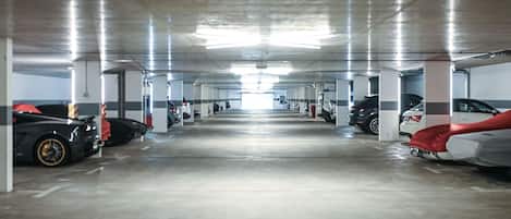 A multi-level underground parking garage with rows of parked cars and concrete pillars.
