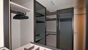 Um closet amplo com prateleiras abertas, cabideiro e porta.