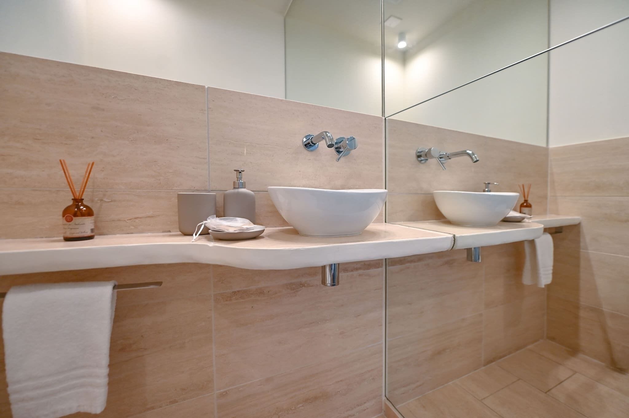 Une salle de bain moderne avec deux lavabos, un porte-serviettes et un miroir.