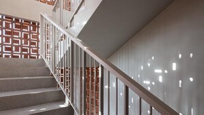A staircase with a modern design, featuring a metal railing and a patterned wall.