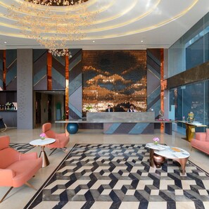 A modern lobby with a large digital display, seating areas, and a patterned floor. - Clarks Collection Grand Sapphire Ajmer (Ajmer)