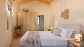 A bedroom with a large bed, wooden wardrobe, and a bedside table with a lamp.