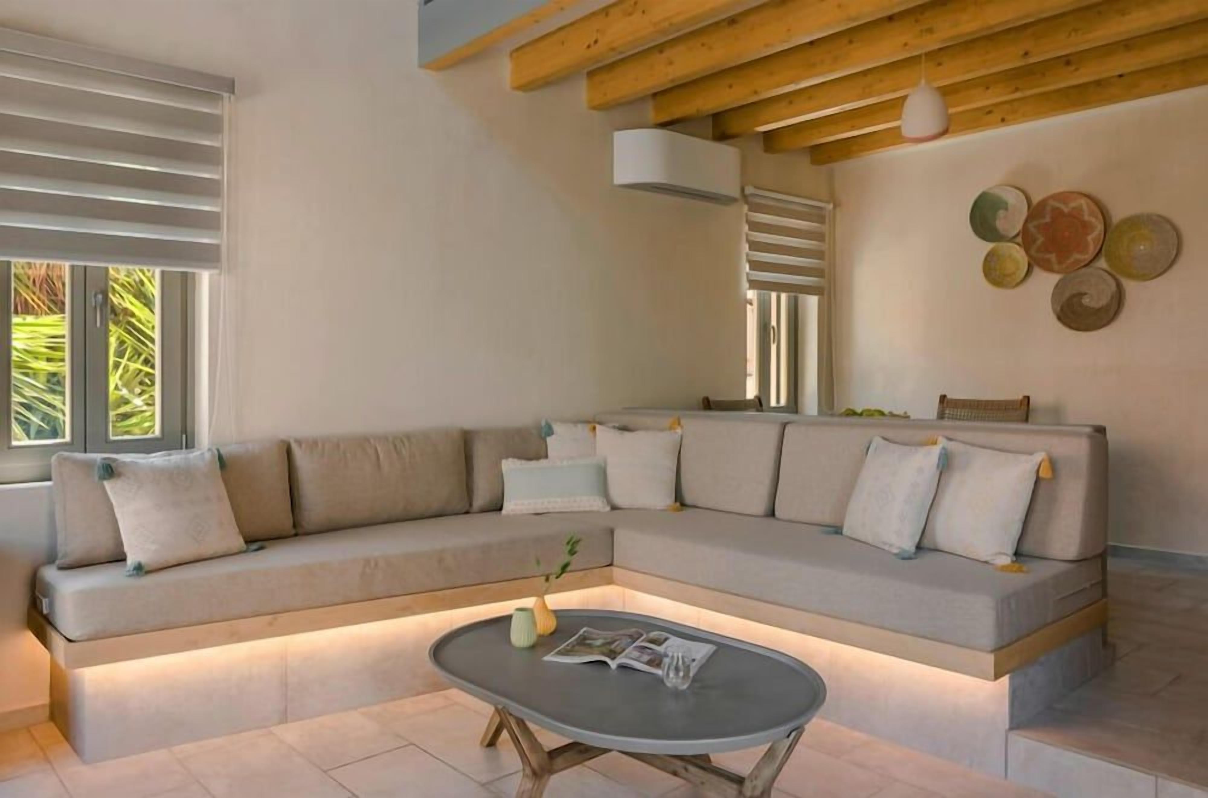 A modern living room with a sectional sofa, a coffee table, and a wall-mounted light fixture.