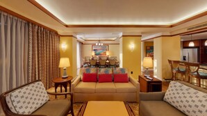 A hotel room with a sofa, armchairs, a dining area with chairs, and a kitchen area. - Ko Olina | Disney Family Adventure | Lagoon + Pool | 3BR Sleeps 12 (Kapolei)